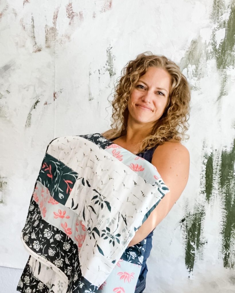 Artist with fabric designs and quilt